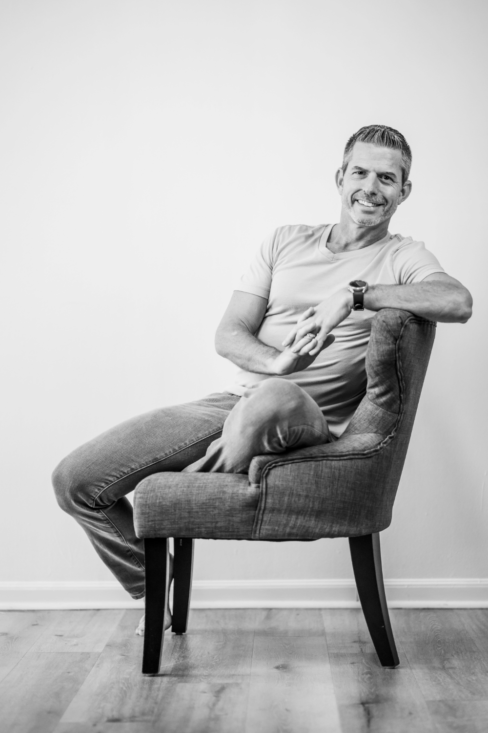 Portrait of Shawn Condra, author and mindset coach, sitting casually in a chair smiling